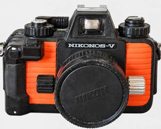 Nikonos-V film camera with orange-and-black body, capped lens, and visible wear.