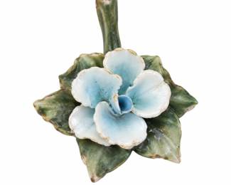 Pale blue ceramic flower ornament with green leaves