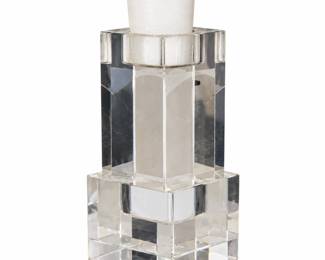 Tall clear geometric candle holder with a white candle.