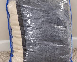 Gray-and-cream bedding in a clear storage bag.