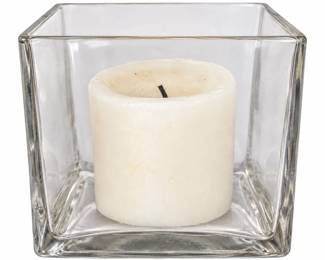 Short clear block candle holder with a white candle.