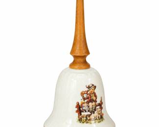 Ceramic handbell with a wooden handle and illustrated scene.