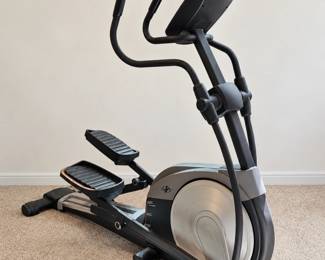 Elliptical trainer with moving handles, wide foot platforms, and console.