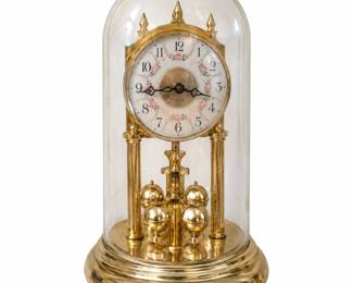 Gold-tone domed clock with a floral dial and ball pendulum.