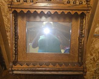 antique Victorian Eastlake-style oak shaving mirror with a built-in shelf and a lower towel bar