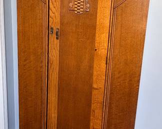 vintage Art Deco-style oak wardrobe or armoire, featuring characteristic geometric wooden inlay and curved top detailing