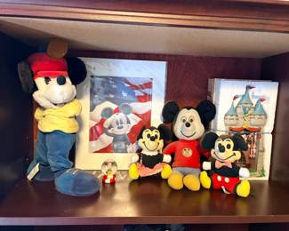 collection of Disney Mickey and Minnie Mouse plush dolls, a framed patriotic print with an American flag, a small snow globe, and a boxed Cinderella Castle photo frame set