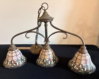 vintage 3-light Tiffany-style stained glass chandelier featuring bell-shaped shades with a geometric pink and cream pattern and a colorful floral border along the bottom edge