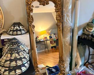 full-length mirror features an elaborately carved gold Baroque frame with detailed floral scrollwork at the top