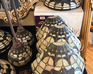Tiffany-style stained glass lamp shades with an iridescent scalloped design and dark accent motifs, wall sconces