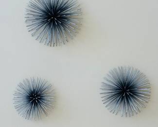 Set of three metal starburst wall sculptures in varying sizes
