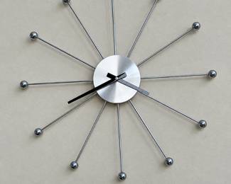 Mid-century modern style starburst wall clock with a silver-tone