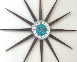 Mid-century modern starburst wall clock with long, tapered dark wood rays