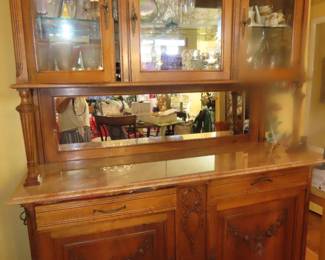 Large china cabinet/bar/buffet with mirrored back and marble counter.