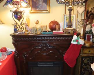 Fireplace with Tiffany style table lamps, onyx bookends, Murano angels and Bird on branch.