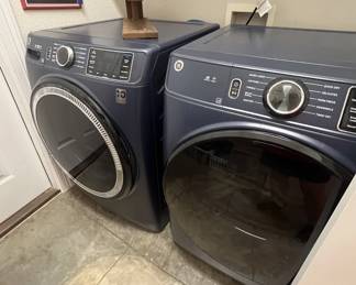 Modern GE front-load washer and dryer set in a dark blue finish.