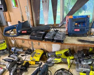 Assortment of Ryobi power tools, including a mini chainsaw, jigsaw, angle grinder, reciprocating saw, and various battery chargers,