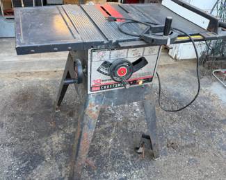 Vintage Sears Craftsman 10-inch motorized table saw with extension wings, showing some surface rust and wear from use.