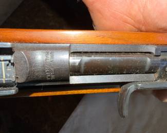 Close-up of a vintage .30 caliber carbine rifle showing the receiver markings and wooden stock.