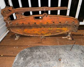 Vintage Specialty Tool Mfg. Co. "The Improved Handy" asbestos shingle cutter, featuring a heavy cast iron frame with weathered orange paint and surface rust.