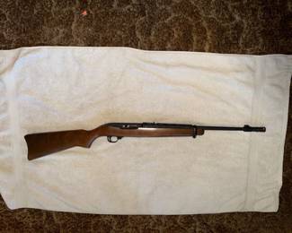 Ruger 10/22 semi-automatic rifle with a wood stock and black barrel, displayed on a white towel.