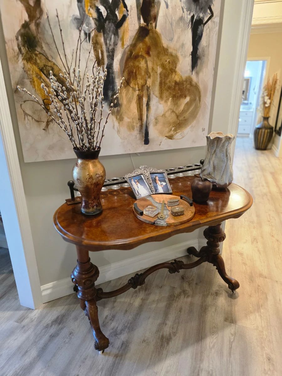 Victorian-style burl walnut console with carved trestle base and vases