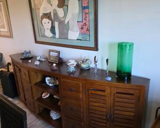 Teak-finish louvered bow-front sideboard with seashells and candlesticks
