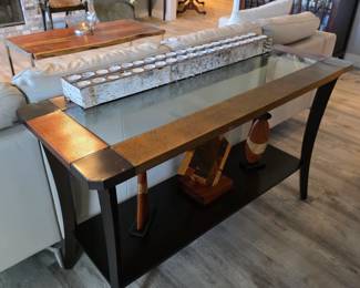 Glass-inset copper-tone sofa table with carved wood figural sculptures