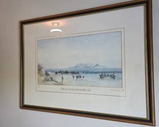 Framed watercolor-style print of fishing boats on beach below mountain