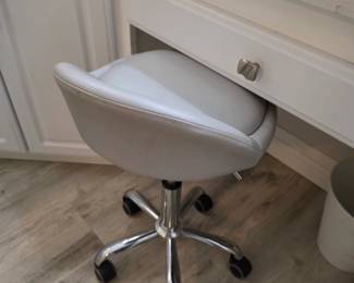Gray faux leather tub-seat swivel vanity stool on chrome casters