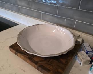 White scalloped-rim ceramic serving bowl on end-grain butcher block