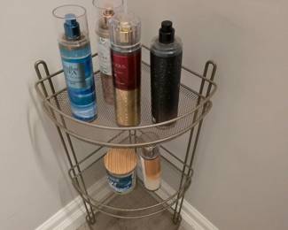 Bronze-tone metal three-tier corner caddy with body mists and candle