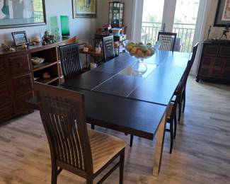 Espresso dining table with chrome legs and six slat-back dining chairs