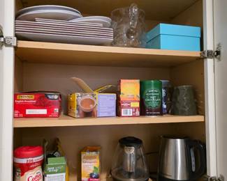 Glass and stainless electric kettles with white plates and boxed teas