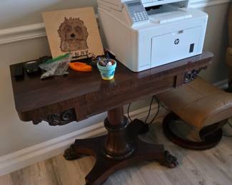 Regency-style mahogany pedestal games table with carved scroll apron