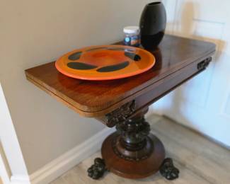Regency-style fold-over card table with carved paw feet and art glass bowl