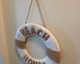 White-washed wood Beach House life ring sign with jute rope wraps