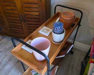 Wood tray-top rolling cart with black metal frame and terracotta pots