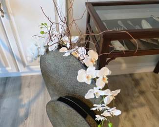 Tall gray textured ceramic vase with faux white orchids and curly branches