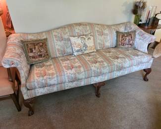vintage Chippendale-style camelback sofa features classic carved mahogany ball-and-claw feet and a traditional striped floral print upholstery