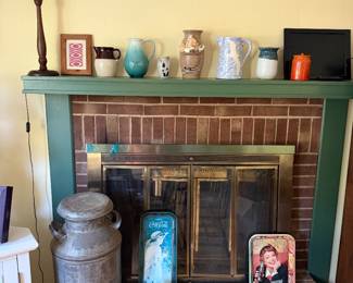 Fireplace with pottery pitchers and vases on the mantel, galvanized milk can and vintage Coca-Cola trays on the hearth