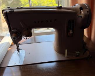 Vintage Singer sewing machine in a wood cabinet