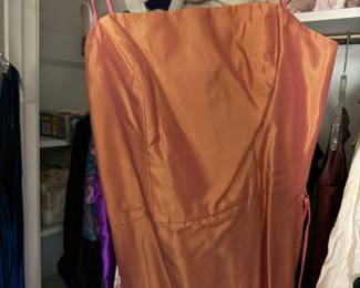 Copper satin spaghetti strap gown, with porcelain dolls on the shelf above