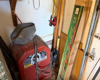 Arc welder, long handled shovels, a boxed air scraper and a vintage radio on the shelf