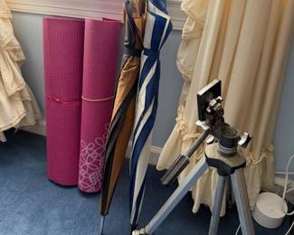 Two pink yoga mats, golf umbrellas and a camera tripod