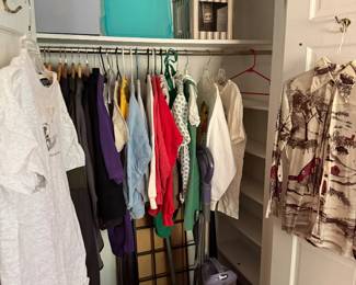 Closet of clothing with storage bins and a Shark upright vacuum
