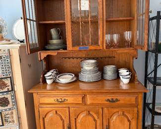 Maple china hutch with glazed upper doors, filled with china and glassware
