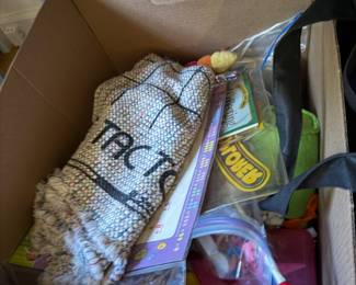 Box of children's games and toys with a woven tic tac toe mat