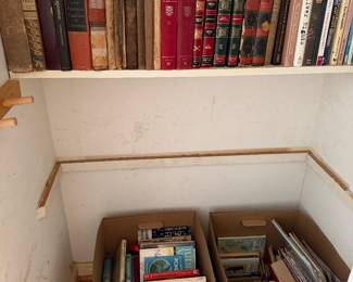 Shelf of antique cloth bound books with two boxes of additional books