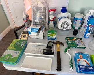 Household supplies including Swiffer wipes, caulk, weatherstripping, a hammer and cleaning sprays